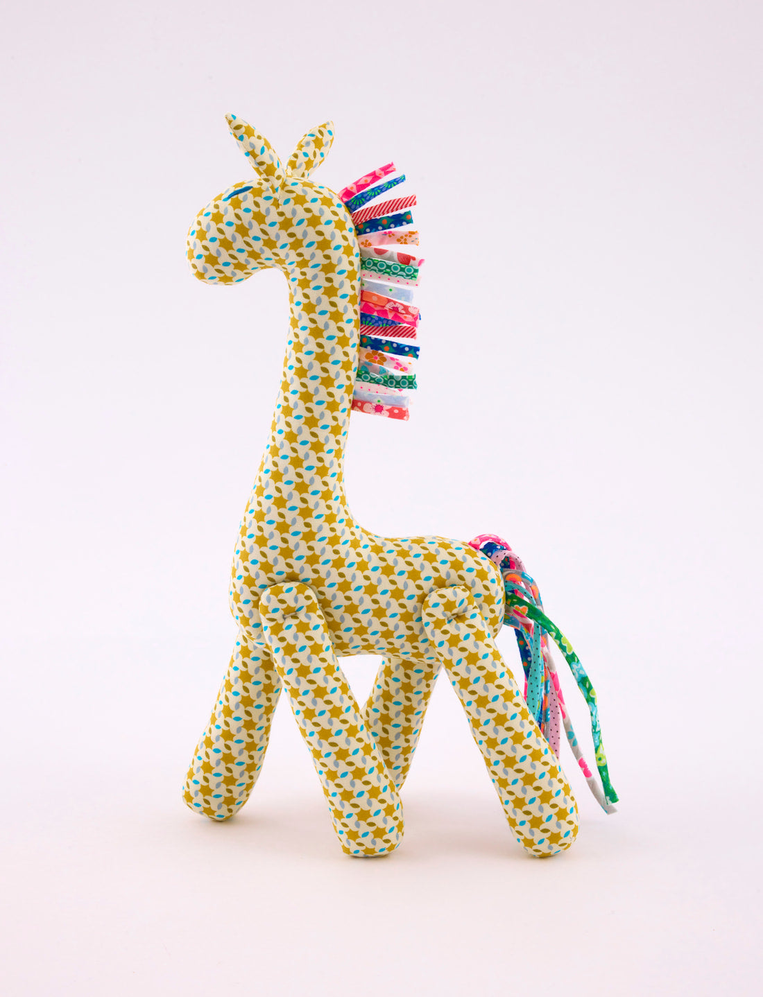 Doudou Girafe Moussem Safran avec des motifs géométriques